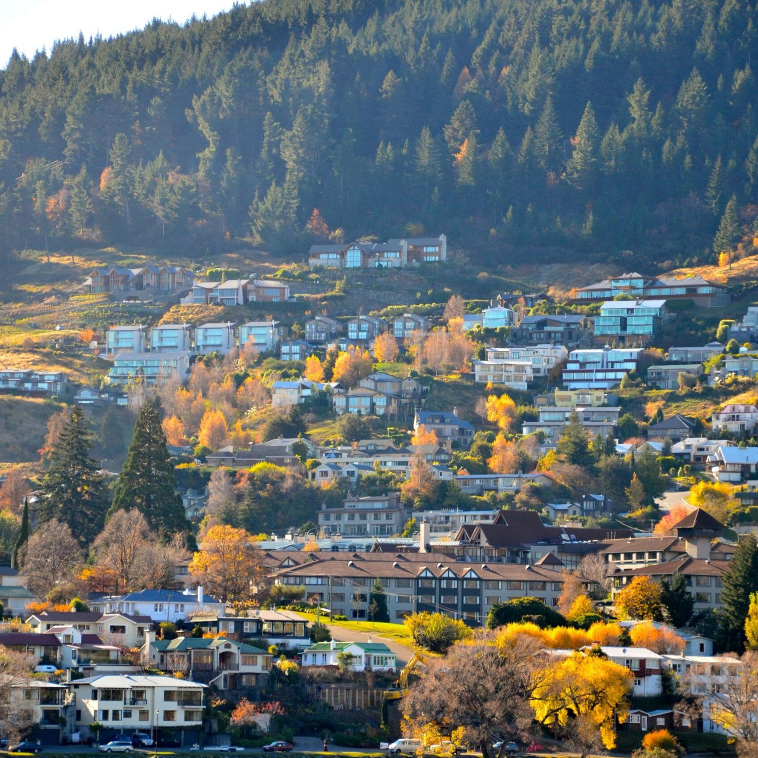 A stunning autumn landscape of Queenstown, New Zealand, with colorful foliage and mountain backdrop.